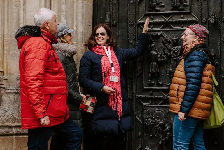Private guide in Prague showing hidden symbols on a historic door to guests during the Dan Brown Secret of Secrets Tour.