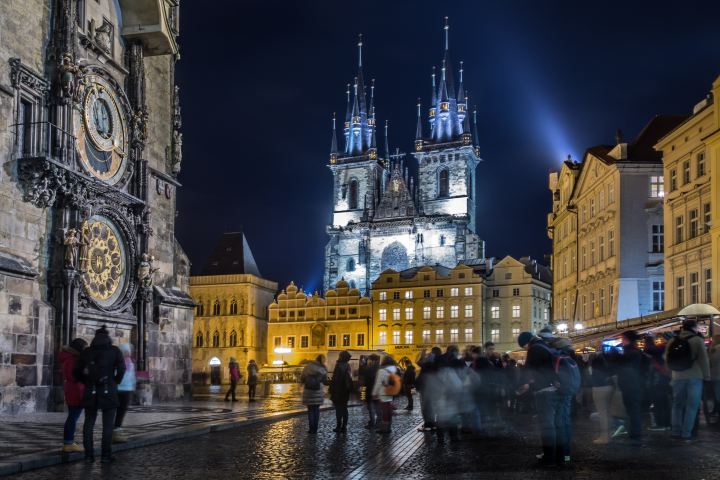 the Old Town Square at night with the Astronomical clock on the left and the Tyn Church in the Background