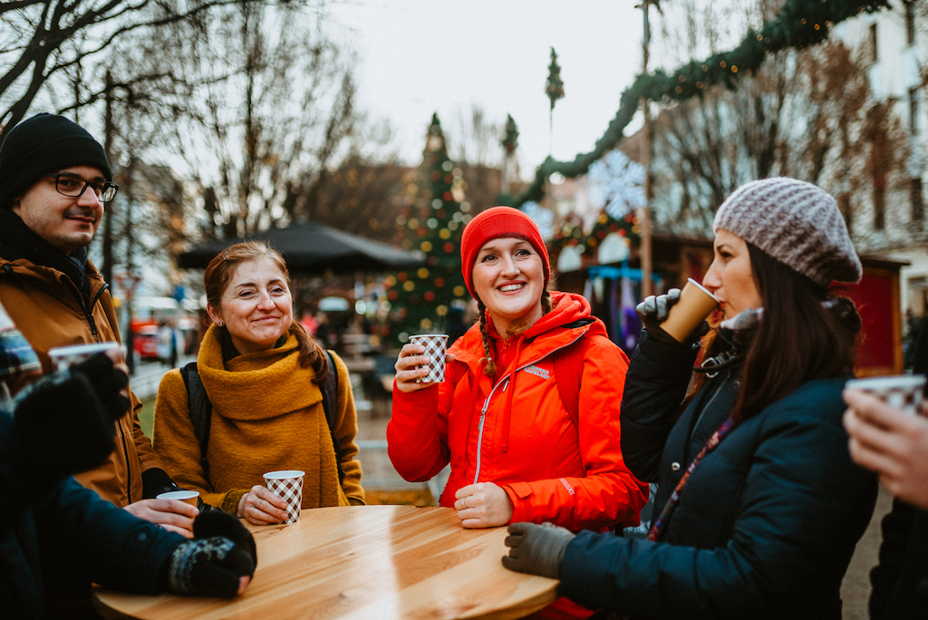 a Prague City Adventures tour guide raising a glass together with a group of tourists on the winter markets in Prague