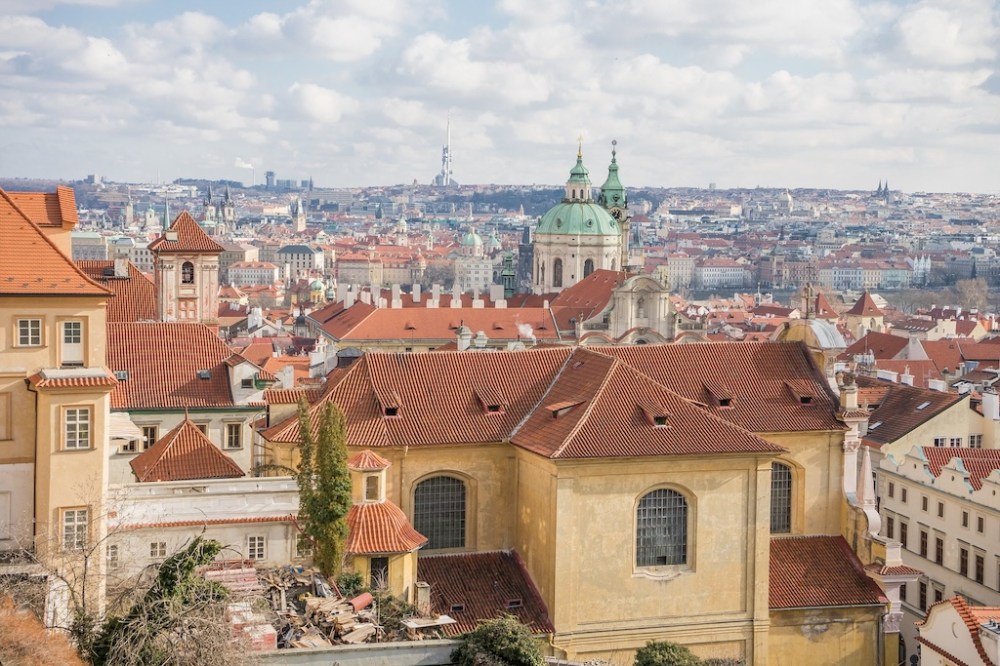 a stunning view of the Lesser Town of Prague and the St. Nicolas Church that you can enjoy from the Kuchyn restaurant at the Prague Castle